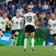Germany players run toward Klara Bühl to celebrate their penalty shootout victory against France in the UEFA Women's Euro 2025 quarterfinal at St. Jakob-Park in Basel, Switzerland.