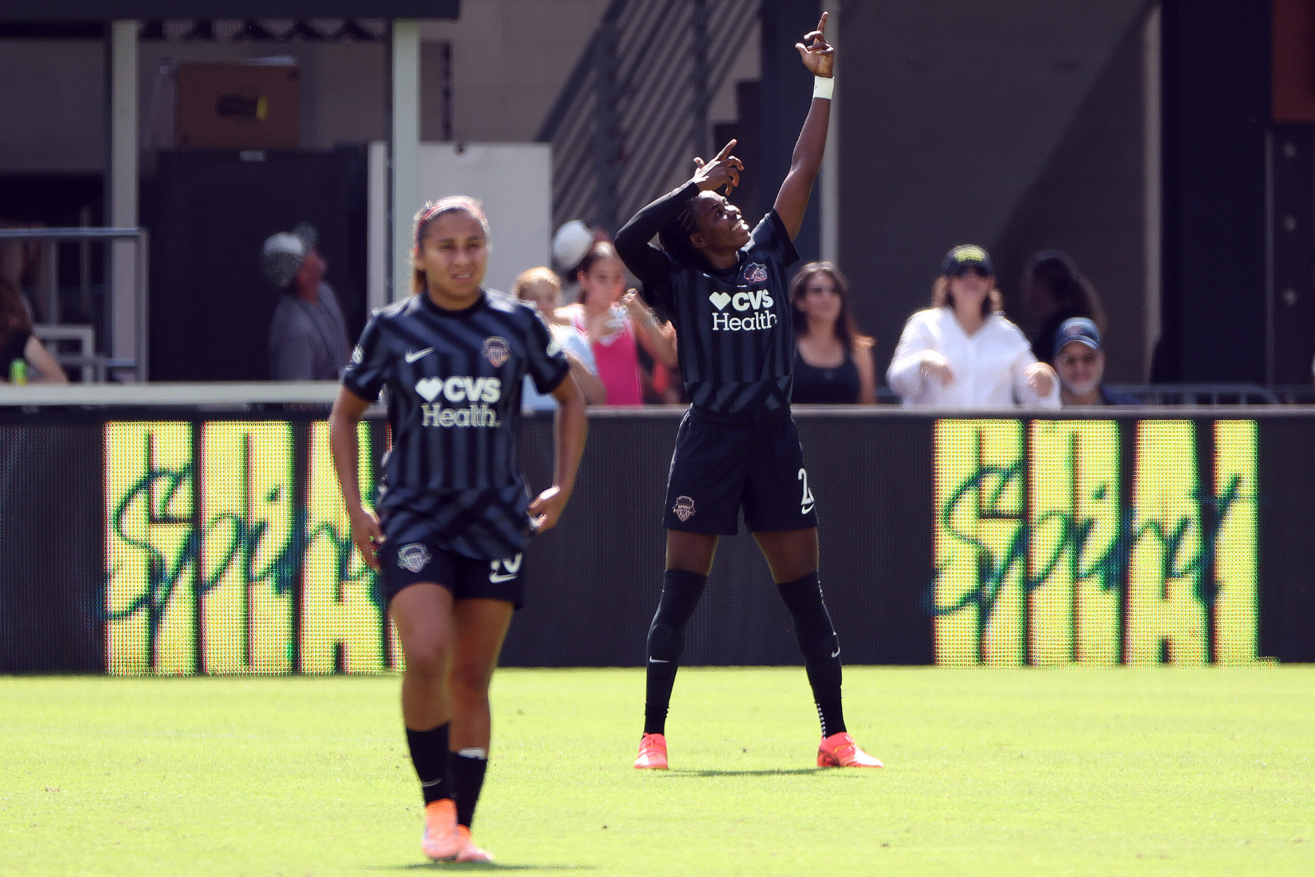 Gift Monday makes a shooting arrow motion in the background, celebrating a goal.